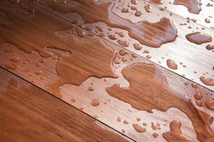 Wood floor with water damage, indicating the need to refinish wood floors