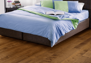 A bedroom with a gleaming, well-maintained wood floor, showcasing the results of effective wood floor maintenance